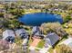 Stunning aerial view of a lakeside property with mature trees and a brick-paved driveway at 352 Misty Oaks Run, Casselberry, FL 32707