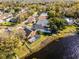 Scenic aerial view featuring a home with a screened-in pool, surrounded by mature trees and serene lakeside living at 352 Misty Oaks Run, Casselberry, FL 32707