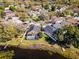 Breathtaking aerial view of a home with a screened-in pool, lush greenery, and stunning lake access at 352 Misty Oaks Run, Casselberry, FL 32707