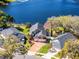 Aerial view of a well-maintained home next to a lake with a brick driveway and mature landscaping at 352 Misty Oaks Run, Casselberry, FL 32707
