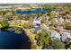 A serene aerial view of a neighborhood, showcasing lake access and vibrant landscaping at 352 Misty Oaks Run, Casselberry, FL 32707