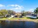 Stunning lakefront home featuring a screened-in pool, lush lawn, and backyard perfect for relaxation and entertainment at 352 Misty Oaks Run, Casselberry, FL 32707