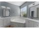 Luxurious bathroom featuring a soaking tub, double vanities, and a window for natural light at 352 Misty Oaks Run, Casselberry, FL 32707