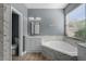 Bright bathroom showcasing double vanity sinks, a soaking tub, and modern finishes and fixtures at 352 Misty Oaks Run, Casselberry, FL 32707