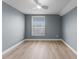 Bright bedroom showcasing a ceiling fan, fresh neutral paint, wood-look flooring, and a window at 352 Misty Oaks Run, Casselberry, FL 32707