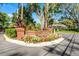 Community entrance featuring beautiful landscaping, flowers, and prominent signage at 352 Misty Oaks Run, Casselberry, FL 32707