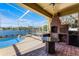 Outdoor patio features a built-in brick grill, granite table, and view of the in-ground pool at 352 Misty Oaks Run, Casselberry, FL 32707