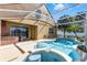 This screened in-ground pool and hot tub overlooks the home and landscaped backyard at 352 Misty Oaks Run, Casselberry, FL 32707