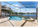 This screened in-ground pool and hot tub overlooking a serene lake is perfect for entertaining at 352 Misty Oaks Run, Casselberry, FL 32707