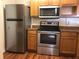 Modern kitchen equipped with stainless steel appliances, wooden cabinets, and ample countertop space at 3714 Palm Desert Ln # 5337, Orlando, FL 32839