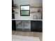 Close-up of bar featuring custom cabinetry, mini-fridge, marble countertops, and open shelving at 382 Riverside Dr, Ormond Beach, FL 32176