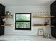 Stylish bar showcasing open shelving, unique glassware, framed art, and modern decor at 382 Riverside Dr, Ormond Beach, FL 32176