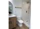 Modern bathroom with wood vanity, white tiles, gold fixtures, and a glass-enclosed shower at 382 Riverside Dr, Ormond Beach, FL 32176