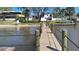 Private wood dock on the water leading to a two story home with a sandy beach at 382 Riverside Dr, Ormond Beach, FL 32176