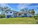 Beautifully landscaped two-story home with a modern design, a spacious front yard, and mature trees at 382 Riverside Dr, Ormond Beach, FL 32176