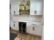 The kitchen area boasts stylish white cabinets, a wine fridge, and modern lighting over a marble backsplash at 382 Riverside Dr, Ormond Beach, FL 32176