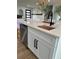 Stylish kitchen island with white cabinets, dishwasher, bar stool seating, and a sleek black faucet at 382 Riverside Dr, Ormond Beach, FL 32176