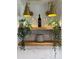 Close-up of a shelf with decorative lighting, plants, wine glasses, and a bottle, creating an elegant touch at 382 Riverside Dr, Ormond Beach, FL 32176