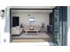 Bright living room featuring stylish furniture, a modern round mirror, and an open patio view at 382 Riverside Dr, Ormond Beach, FL 32176