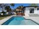 Beautiful pool area featuring a sparkling blue pool, deck, patio, and meticulous landscaping at 382 Riverside Dr, Ormond Beach, FL 32176