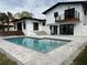 Backyard pool area with patio, landscaping, second story balcony and home exterior at 382 Riverside Dr, Ormond Beach, FL 32176