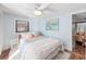 Comfortable bedroom features light blue walls, hardwood floors, a ceiling fan, and a window at 430 E Crystal Lake St, Orlando, FL 32806