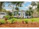 Charming single story home featuring mature landscaping, lawn, and palms at 430 E Crystal Lake St, Orlando, FL 32806