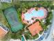 Overhead angle of a community pool, clubhouse, tennis courts and parking lot at 4715 Coral Castle Dr, Kissimmee, FL 34746