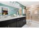 Bright bathroom with dual sinks, large mirror, and glass-enclosed shower, offering a modern and functional space at 4715 Coral Castle Dr, Kissimmee, FL 34746