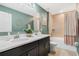 Well-lit bathroom with double sinks, vanity, a shower-tub combination, and modern fixtures at 4715 Coral Castle Dr, Kissimmee, FL 34746