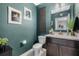 Stylish half bathroom boasts deep teal walls, neutral vanity and matching tile flooring at 4715 Coral Castle Dr, Kissimmee, FL 34746
