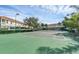 Community tennis court surrounded by mature landscaping and residential buildings at 4715 Coral Castle Dr, Kissimmee, FL 34746
