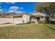 Inviting single-story home boasting an attached two-car garage, well-kept lawn and mature trees at 545 Ne 45Th Ct, Ocala, FL 34470