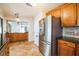 Spacious kitchen boasts stainless steel refrigerator, wooden cabinets, tile backsplash and flooring at 545 Ne 45Th Ct, Ocala, FL 34470