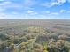 Expansive aerial shot showcasing a large home nestled within a densely wooded area at 5500 State Road 33, Clermont, FL 34714