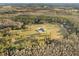 Aerial view of the estate surrounded by dense woods, revealing a circular driveway and beautiful lawn at 5500 State Road 33, Clermont, FL 34714