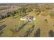 A sprawling estate with a long driveway, large lawn, swimming pool, and surrounded by a dense forest at 5500 State Road 33, Clermont, FL 34714