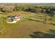 Aerial shot of the home and manicured property featuring a pool, lush landscaping, and surrounding trees at 5500 State Road 33, Clermont, FL 34714