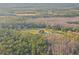Aerial shot of estate featuring a luxurious home surrounded by a vast expanse of trees and manicured lawns at 5500 State Road 33, Clermont, FL 34714