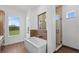 Modern bathroom with a soaking tub, glass-enclosed shower, tile accents, and large windows at 5500 State Road 33, Clermont, FL 34714