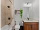 Bathroom featuring a shower/tub, neutral tile, wood vanity and a framed mirror with modern lighting at 5500 State Road 33, Clermont, FL 34714
