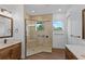 Modern bathroom featuring a glass-enclosed shower with tile surround, and double sink vanities at 5500 State Road 33, Clermont, FL 34714