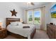 Cozy bedroom with a wood-framed bed, matching dresser, and a large window view at 5500 State Road 33, Clermont, FL 34714