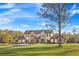 Beautiful home featuring a stone facade, manicured lawn, and mature trees, set against a clear blue sky at 5500 State Road 33, Clermont, FL 34714