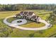 Elegant two-story home with circular driveway, manicured landscaping, and sprawling green lawn at 5500 State Road 33, Clermont, FL 34714