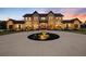 Stately home featuring stone accents, an elegant circular driveway, and lush landscaping with evening illumination at 5500 State Road 33, Clermont, FL 34714