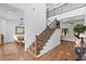 Bright foyer featuring hardwood floors, staircase with iron railing, and open access to the living and dining areas at 5500 State Road 33, Clermont, FL 34714