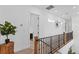 Bright hallway featuring iron railing, white walls, and plenty of natural light from the adjacent windows at 5500 State Road 33, Clermont, FL 34714