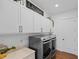 Well-organized laundry room with modern appliances, white cabinets, and stylish decor at 5500 State Road 33, Clermont, FL 34714