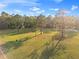 Expansive green lawn featuring mature trees casting long shadows on a bright, sunny day at 5500 State Road 33, Clermont, FL 34714